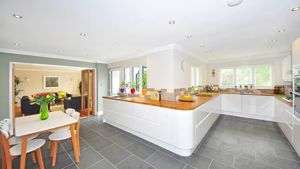 Modern white kitchen with a wood counter and dining area