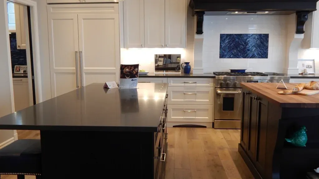 Renovated kitchen with a dark island and hardwood flooring
